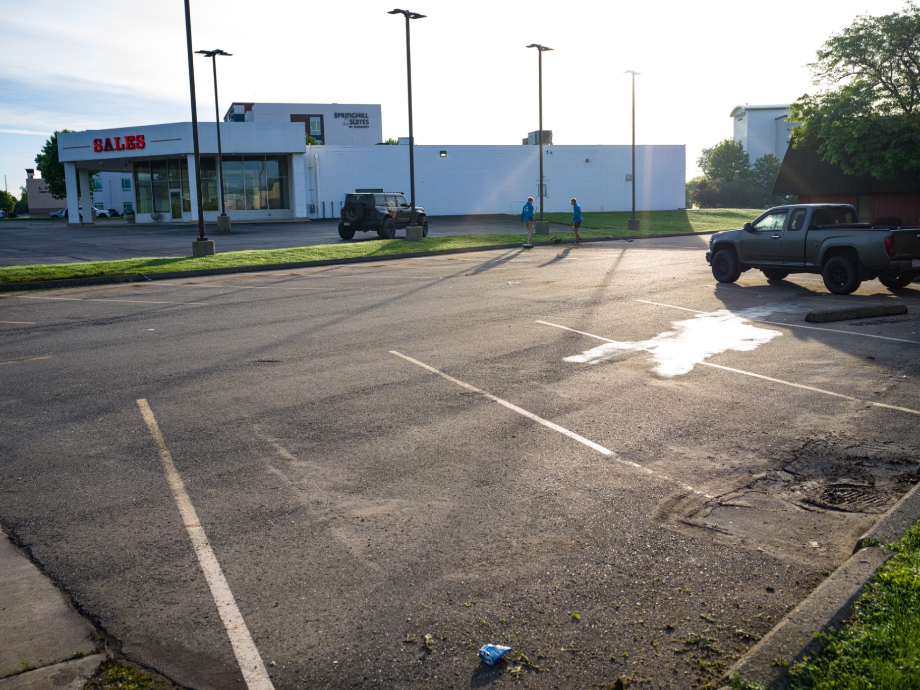 Faded, cracked commercial parking lot with worn line striping before sealcoating