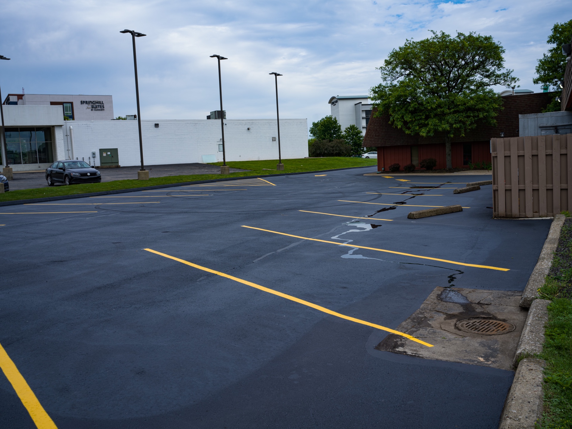 Newly striped parking spaces with fresh yellow paint on jet black sealcoat