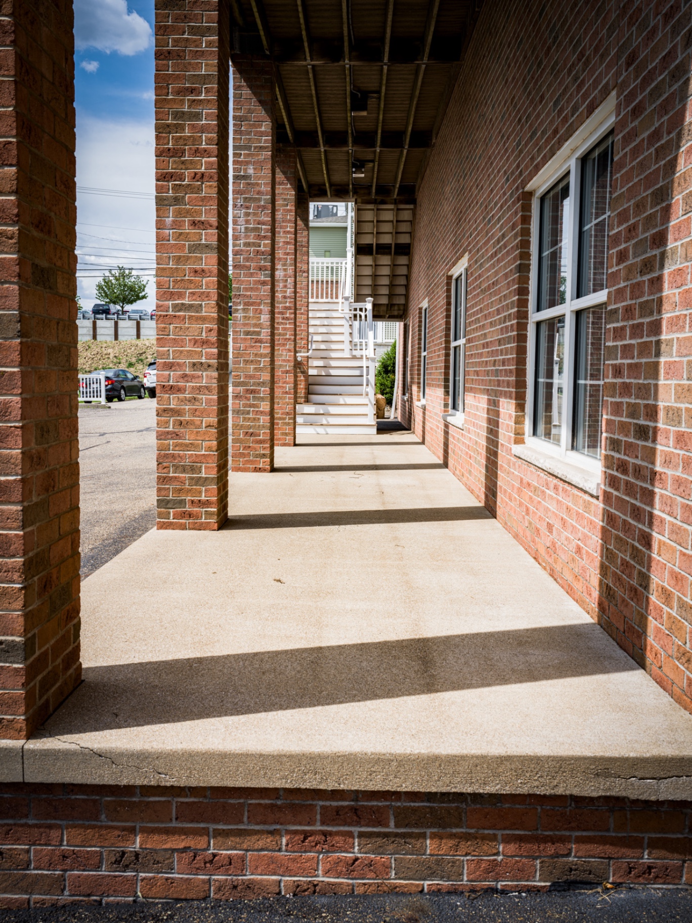Clean, bright concrete walkway between brick columns after pressure washing