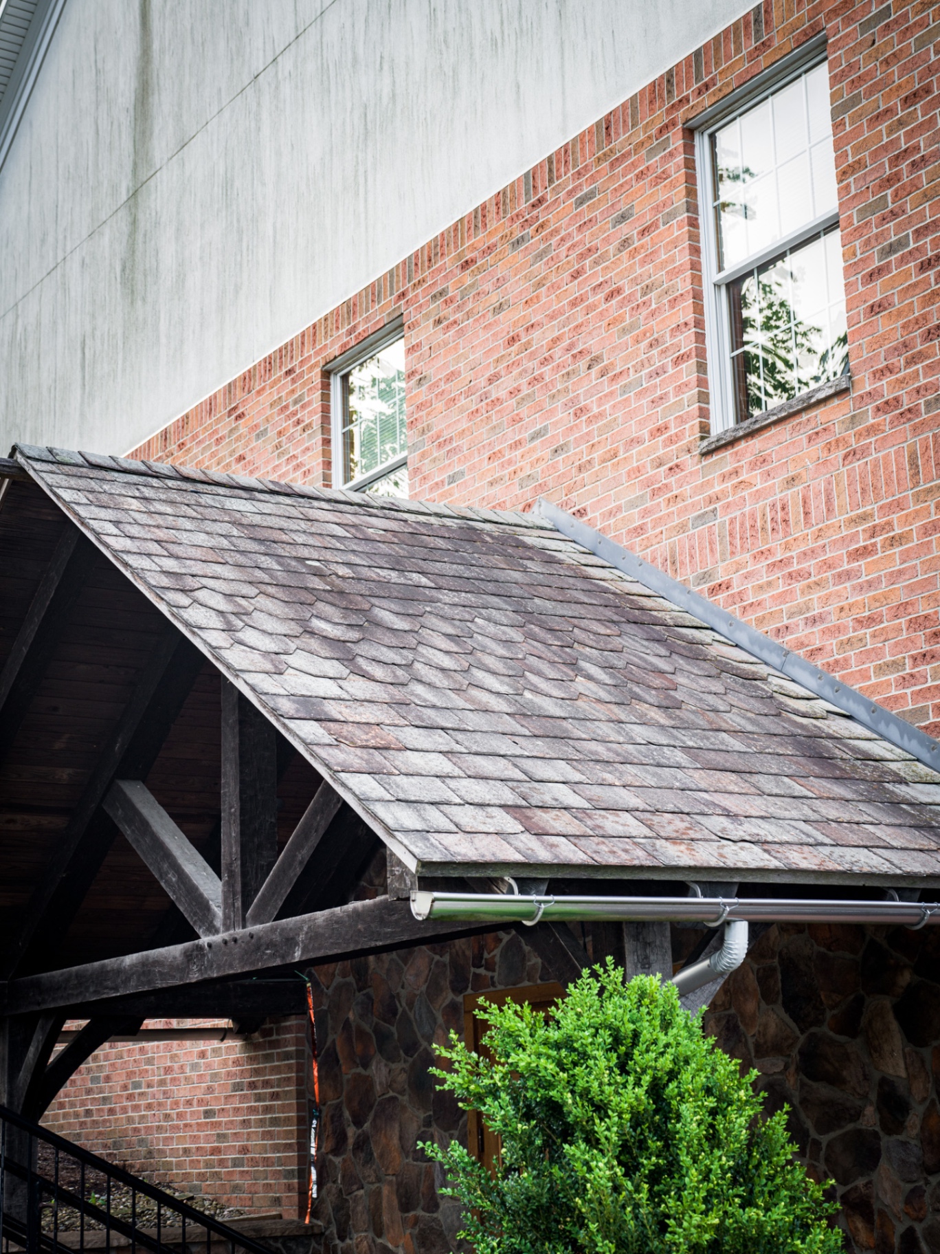 Streaked brick and stucco exterior with dirt and moss before soft washing